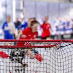 Eine Nachaufnahme von einem Floorballtor, im Hintergrund unscharf einige Personen