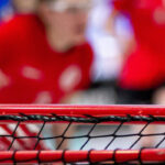 Eine Nachaufnahme von einem Floorballtor, im Hintergrund unscharf einige Personen