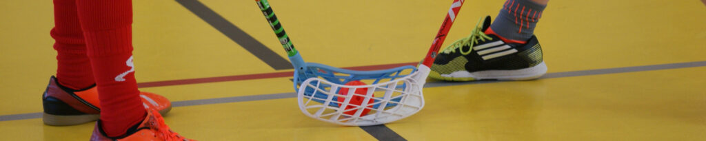 Zwei Personen, die beim Bully bei einem Floorballspiel stehen