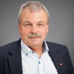 Porträt Uli Hammerl, älterer Herr mit grauen Harren und Schnauzbart, im Hemd mit Jacket