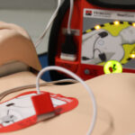 Ein Puppe mit einem Defibrillator, wie sie bei Übungen eingesetzt wird