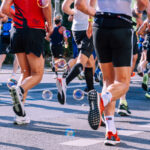 Viele Personen, von denen man meistens nur die Beine und die Oberkörper sieht, die einen Marathon laufen