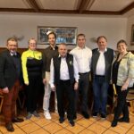 7 Personen, davon 2 Frauen und 5 Männer posieren für ein Gruppenfoto