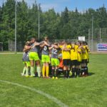 Eine Fußballmannschaft mit Kindern steht zusammen im Kreis