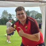 Ein junger mann in roten Fußballtrikot in einer Siegespose