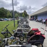Ein Fahrradparkplatz mit vielen Fahrrädern vor einer Sporthalle