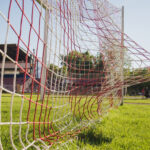 Ein Fußball, der in ein Fußballtor geschossen wird, der Ball zieht das Netz nach hinten