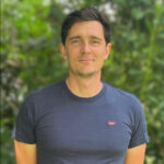 Porträt Roland Jäger, junger Mann mit braunen Haare und einem blauem T-Shirt