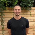 Porträt Sebastian Zinsmeister, junger Mann mit braunen Haaren und einem schwarzen T-Shirt