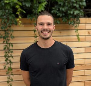 Porträt Sebastian Zinsmeister, junger Mann mit braunen Haaren und einem schwarzen T-Shirt